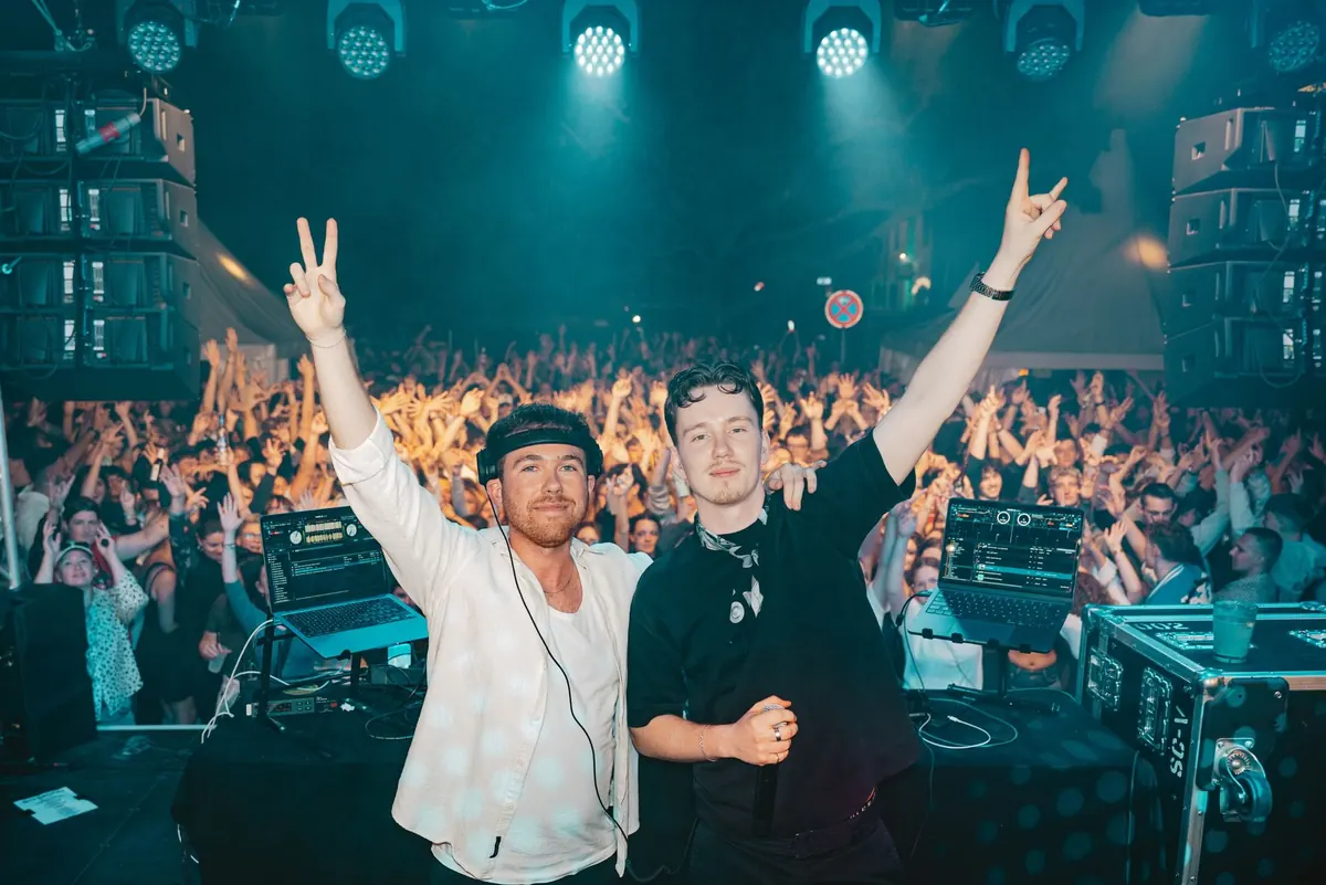 DJ DEAN und ein Gast-DJ jubeln vor vollem Club